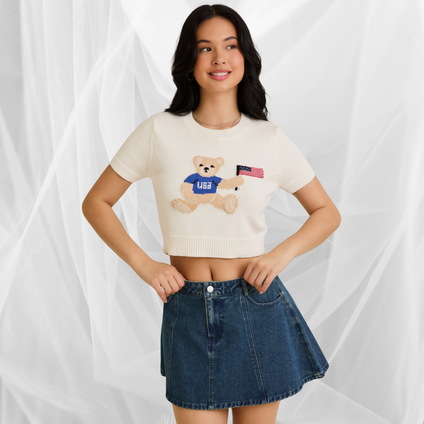 Woman wearing a white USA teddy bear crop top and denim mini skirt – perfect patriotic summer outfit
